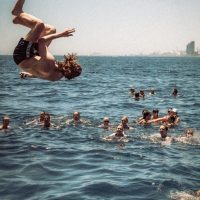 guy backflipping into sea off Barcelona with Barcelona Boat Party Paella And Swim Boat
